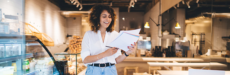 Woman in storefront with papers