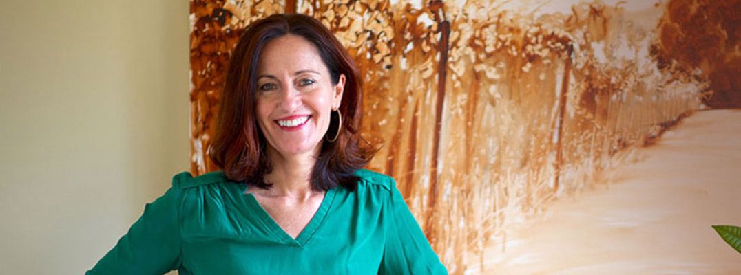 Ann Rea posing in front of one of her paintings