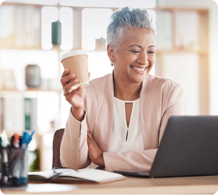Woman drinking coffee on laptop
