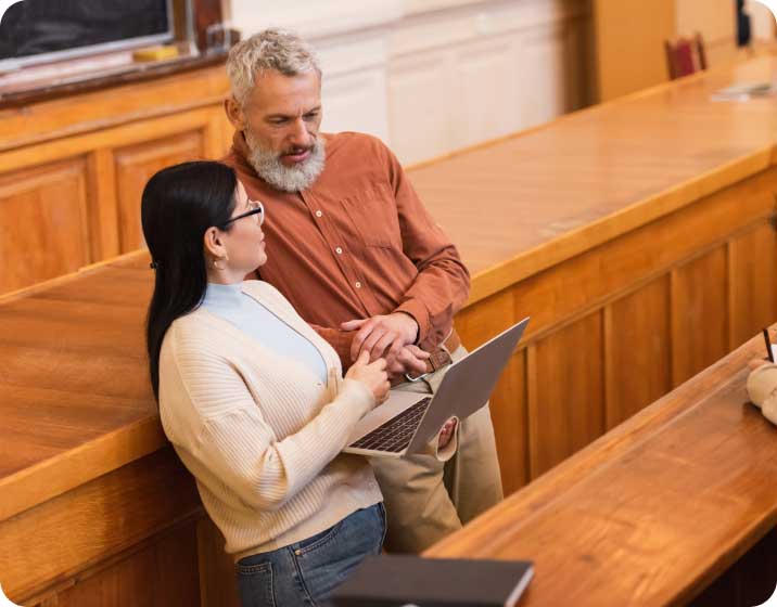 Man helping student on laptop