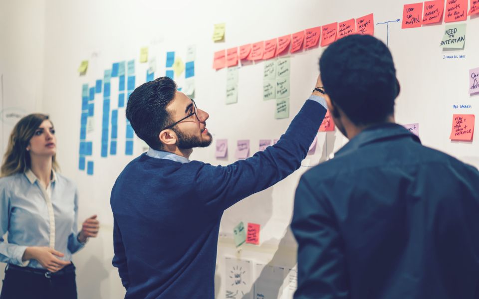 Employees working at idea board