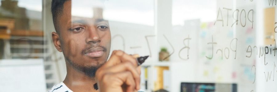 Male entrepreneur exploring calculations on a white board